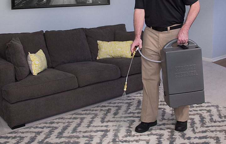 Rug Cleaning Professional Cleaner Stanley Steemer Stanley Steemer Technician Spraying Protector On An Area Rug