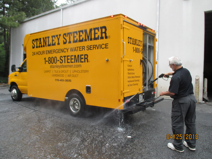 Atlanta Ga Cleaning Services Stanley Steemer Atlanta Georgia Crew Member Cleaning The Exterior Of A Carpet Service Van