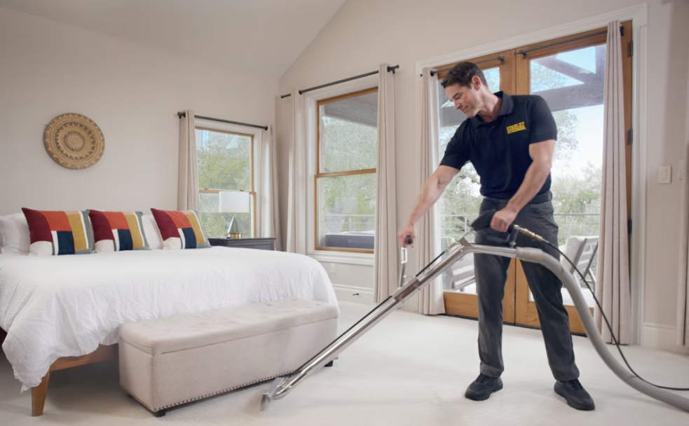 Steemer tech in a bedroom cleaning carpet
